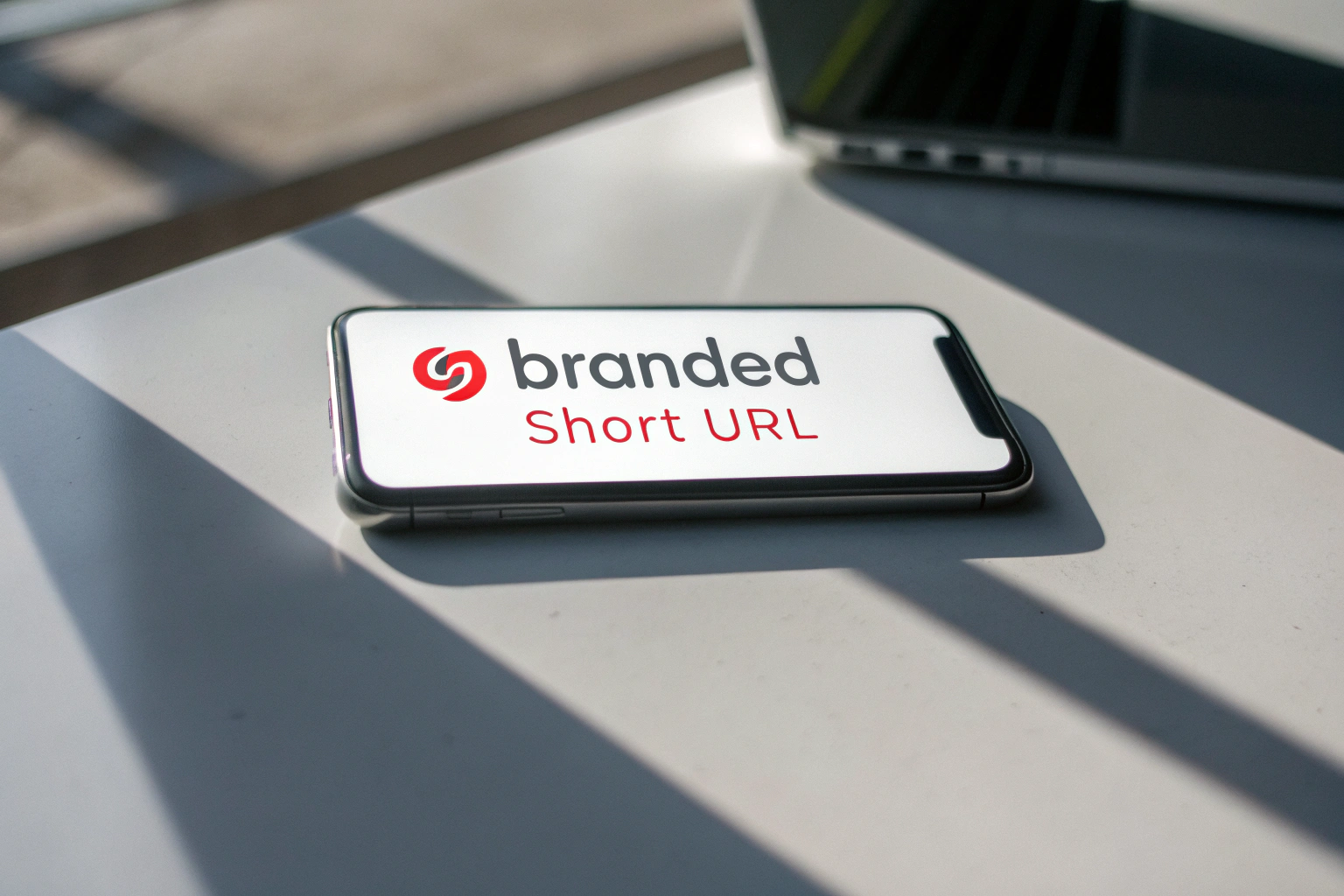 A sleek smartphone in a minimalist workspace showcasing a bold branded short URL with a blurred background to emphasize its importance.